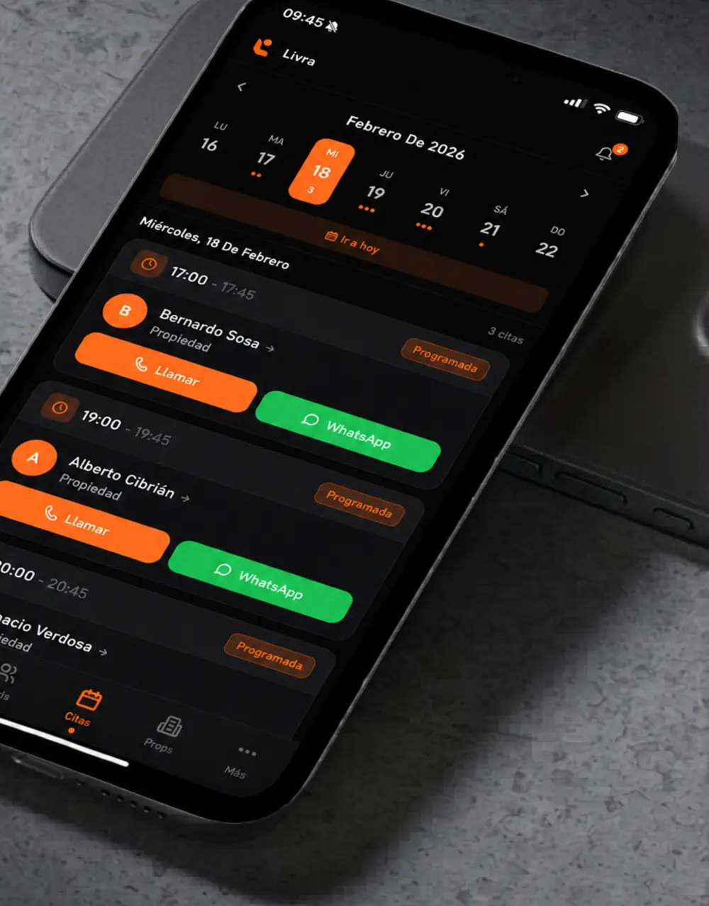 App de Livra en un móvil con las citas del día y botones para llamar o escribir por WhatsApp
